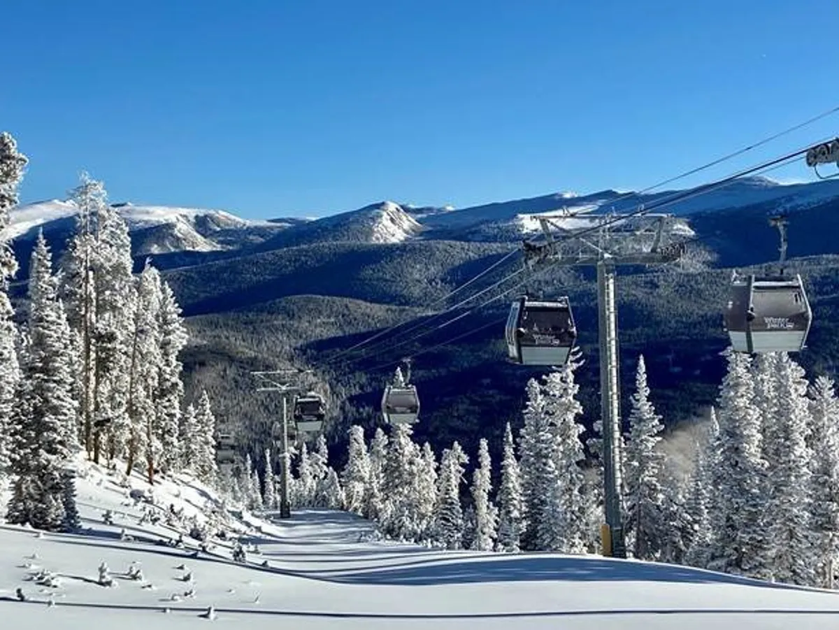 A winter landscape featuring ski gondolas gliding above snow-covered trees, with majestic mountains rising in the background. The scene radiates adventure and the proximity to ski activities, with the gondolas offering panoramic views of the surrounding area.
